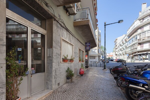 Ein Gebäude mit Schaufenster, Topfpflanzen und einem Motorrad vor der Tür.