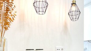 A modern kitchen with two pendant lights, a white countertop, and two black stools. - FLH Marquês Pombal Flat with Balcony (Lisbon)