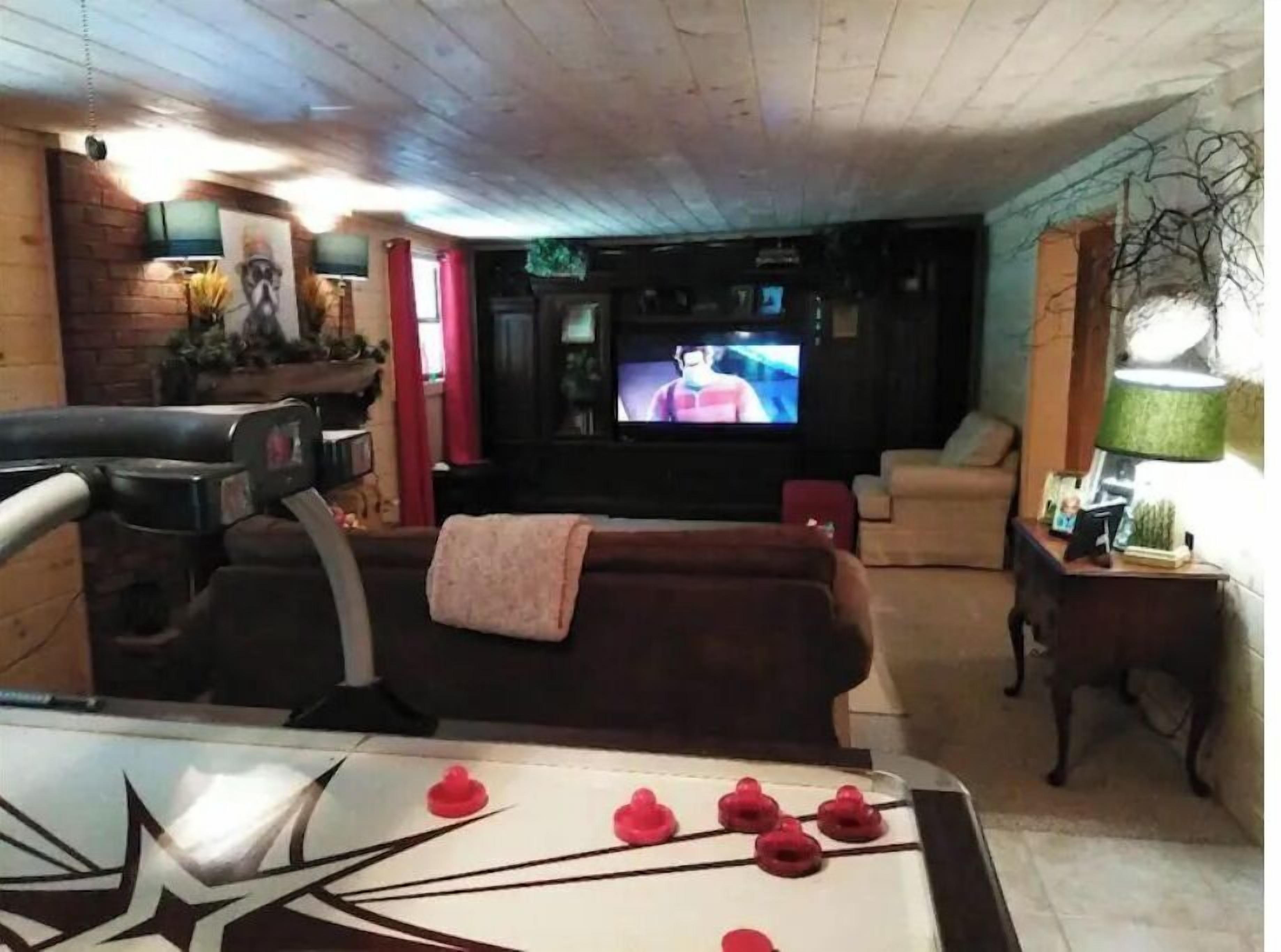 A living room with a television, a sofa, a coffee table, and a fireplace.