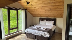 A bedroom with a large window, wooden ceiling, and a bed with white and brown bedding. - Alya Teras Otel (Maçka)