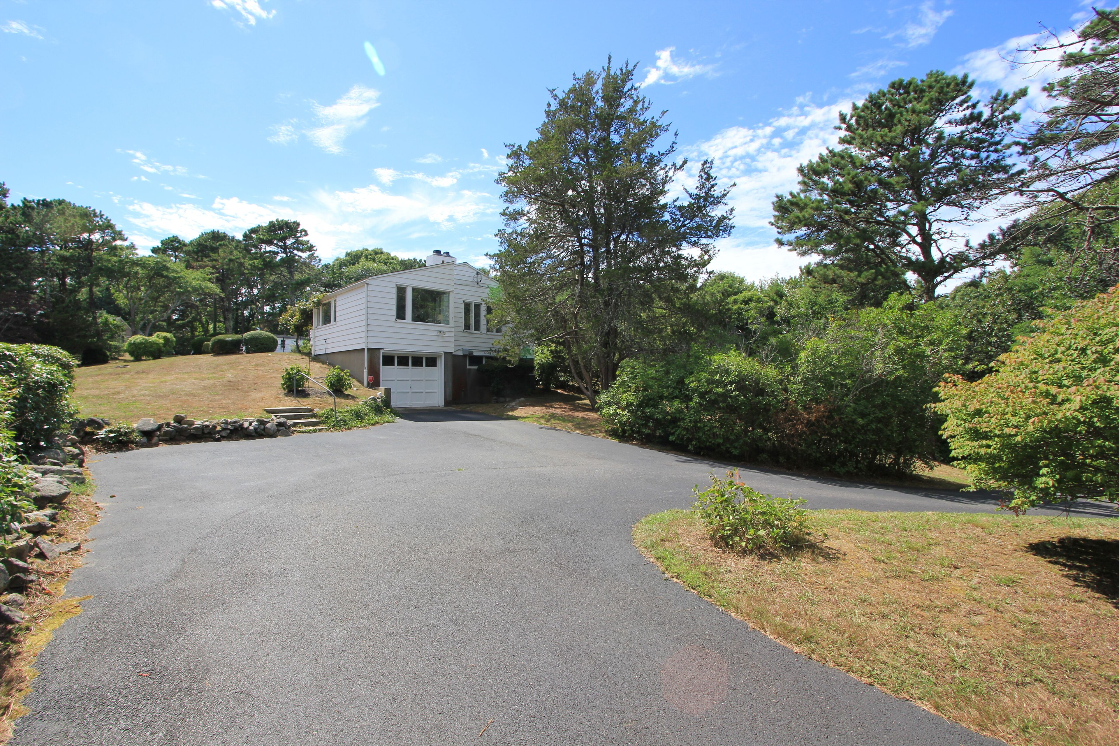 A two-story house with a driveway leading to the front door.