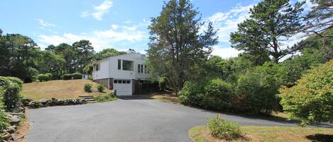 A two-story house with a driveway leading to the front door.