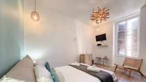 A bedroom with a bed, a TV, a chair, and a window with blinds. - N&J - LE PIERLAS - Place Garibaldi - Very close Old Town (Niza)