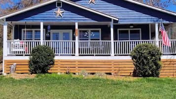Stunning two-story building with a gabled roof and inviting front porch featuring a bench.