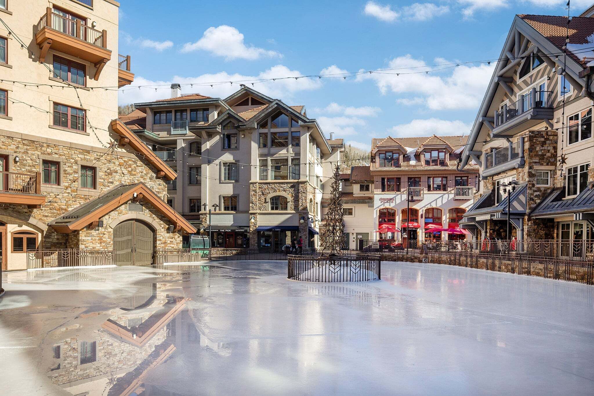 A multi-story hotel with stone facades, balconies, and a central courtyard.