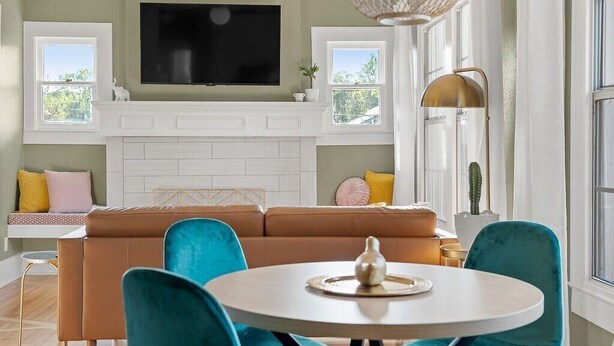 A modern living room with a television, sofa, chairs, and a dining table. - Artsy urban retreat steps from Bishop Arts. Thoughtfully designed with creative touches, a dreamy coffee station, and a king bed you won't want to leave. Gated parking and a responsive host. Repeat guests say it's even more beautiful in person. (Dallas)