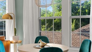A dining area with a round table, teal chairs, a cactus, and a decorative bird on a plate. - Artsy urban retreat steps from Bishop Arts. Thoughtfully designed with creative touches, a dreamy coffee station, and a king bed you won't want to leave. Gated parking and a responsive host. Repeat guests say it's even more beautiful in person. (Dallas)