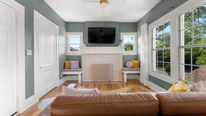 A living room with a fireplace, a large TV, and a sofa. - Artsy urban retreat steps from Bishop Arts. Thoughtfully designed with creative touches, a dreamy coffee station, and a king bed you won't want to leave. Gated parking and a responsive host. Repeat guests say it's even more beautiful in person. (Dallas)