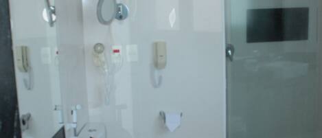 A modern bathroom with a glass shower enclosure, a white sink, and a toilet.