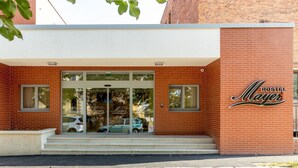 A brick building with a sign reading "Hostel Mayer" and a car parked in front. - Hostel Mayer Superior Veszprém (Veszprem)