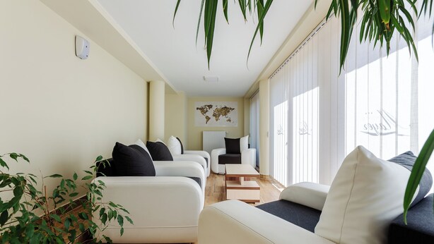A modern living room with a sofa set, a coffee table, and a world map on the wall. - Hostel Mayer Superior Veszprém (Veszprem)