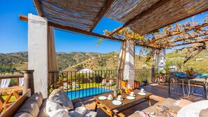 Una terrazza con piscina, posti a sedere all'aperto e vista sulla campagna.
