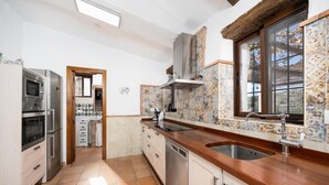 Una cucina moderna con elettrodomestici integrati, un'ampia finestra e una parete rivestita in piastrelle decorative.