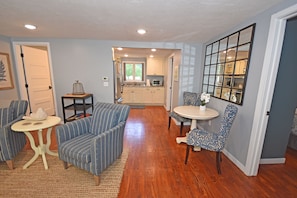 Relax in this open-plan living space with a kitchen area, seating area, and large window.