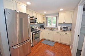 Enjoy cooking in this well-equipped kitchen with a refrigerator, oven, and microwave, along with a dishwasher.