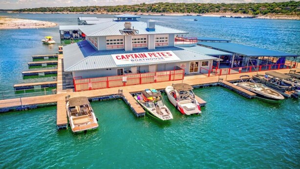 Venevaja nimeltä Captain Pete's, jossa on laiturissa oleva vene, katettu oleskelualue ja näkymä vesistöön.
