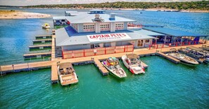 Ein Bootshaus namens Captain Pete's mit einem angedockten Boot, einer überdachten Sitzgelegenheit und Blick auf das Wasser.
