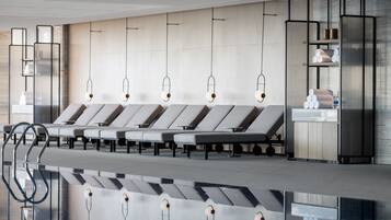 Un área de espera moderna con sillones de descanso, un mostrador de recepción y una zona de piscina.
