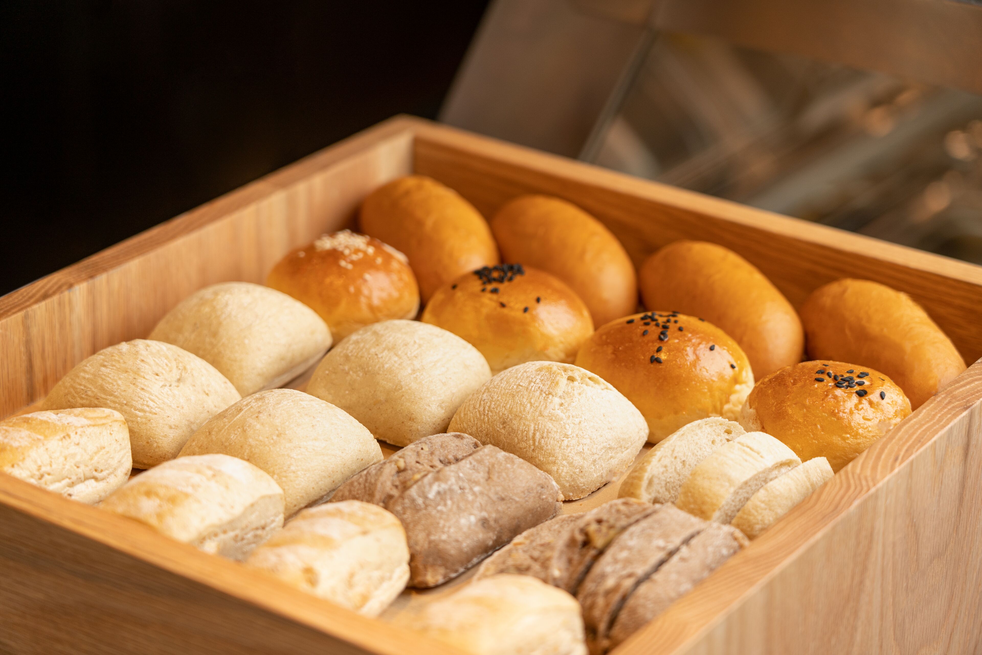 A wooden box containing various types of bread.