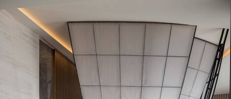A modern interior with a curved ceiling, a bar area, and seating arrangements.