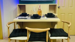 A dining area with a table, chairs, and a flat-screen TV mounted above displaying the YouTube logo.