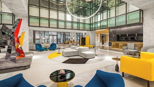 A spacious lobby with a modern design, featuring a large seating area, a unique abstract sculpture, and a large window providing natural light. - Le Méridien Taichung (Taichung)