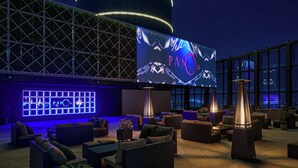 A modern lounge area with comfortable seating, a large illuminated screen, and ambient lighting. - Le Méridien Taichung (Taichung)