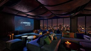A modern lounge with a city view, comfortable seating, and a large screen displaying 'Le Meridien Taichung'. - Le Méridien Taichung (Taichung)