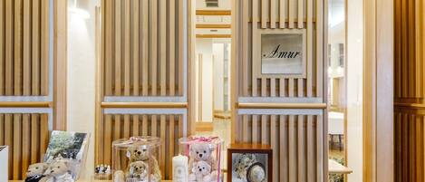 Un área de recepción con un mostrador de madera, fotografías enmarcadas y una placa con el nombre 'Amur'.
