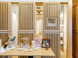 A reception area with a wooden reception desk, framed photographs, and a nameplate reading "Amur".