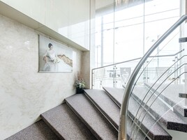 Una escalera con un muro de mármol y un cuadro enmarcado de una novia.