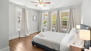 A bedroom with a bed, a ceiling fan, and a window with curtains. - Sweet Sylvan Hills 3/2 - Ten Minutes to Airport (Atlanta)