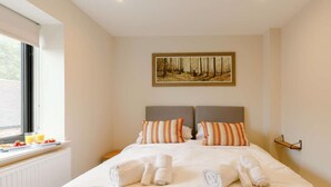 A hotel room with a bed, two pillows, a painting on the wall, and a window with a view. - Fully Accessible-disabled Adapted-hot Tub-pets (Alcester)