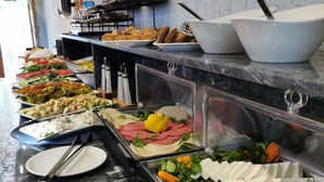 A buffet with various food items and utensils. - LUXX GARDEN HOTEL (Istanbul)