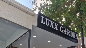 A covered entrance to LUXX GARDEN with a tiled floor, a staircase, and a glass door leading inside. - LUXX GARDEN HOTEL (Istanbul)