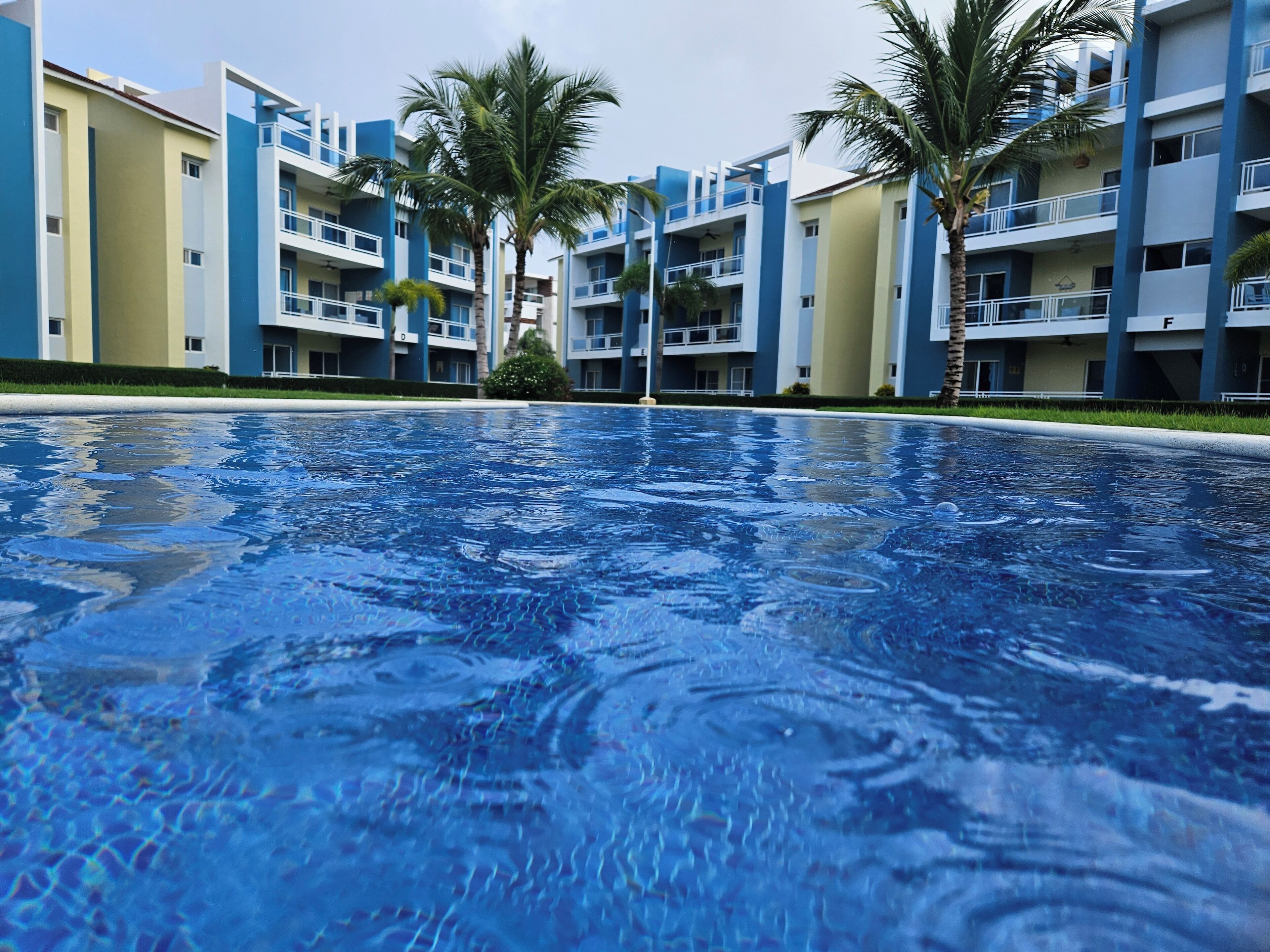 A swimming pool with a view of multi-story buildings in the background.