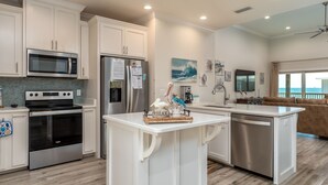A modern kitchen with white cabinetry, stainless steel appliances, and a central island. - Toes in the Sand - Gulf Beachside, 4 Bedroom, 4 Bath, Dog Friendly, Sleeps 12 (Dauphin Island)
