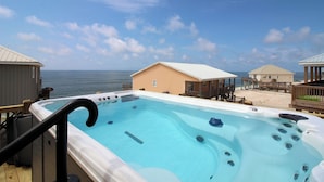A hot tub with a view of the ocean, a wooden deck, and beach houses. - Toes in the Sand - Gulf Beachside, 4 Bedroom, 4 Bath, Dog Friendly, Sleeps 12 (Dauphin Island)