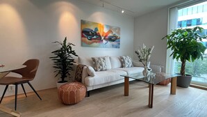 Una sala de estar moderna con un sofá, una mesa de centro y plantas en macetas.