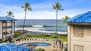 A resort with a pool, palm trees, and ocean views.