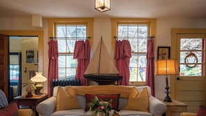 Una sala de estar acogedora con un sofá, dos sillones, una mesita de centro y una chimenea.