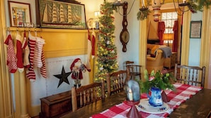 Un comedor acogedor con mantel a cuadros, un árbol de Navidad y decoraciones festivas.