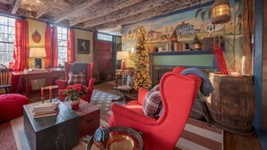 Una sala acogedora con chimenea, un árbol de Navidad y un techo rústico de madera.