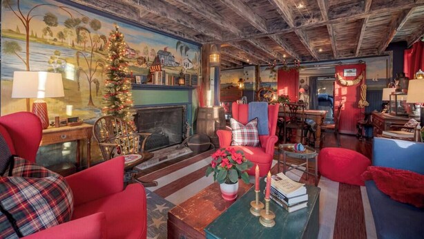 A cozy room with a fireplace, red armchairs, a Christmas tree, and nautical decor. - Historic 1807 Williams Home... A Nautical New England Inspiration!  (Old Mystic)