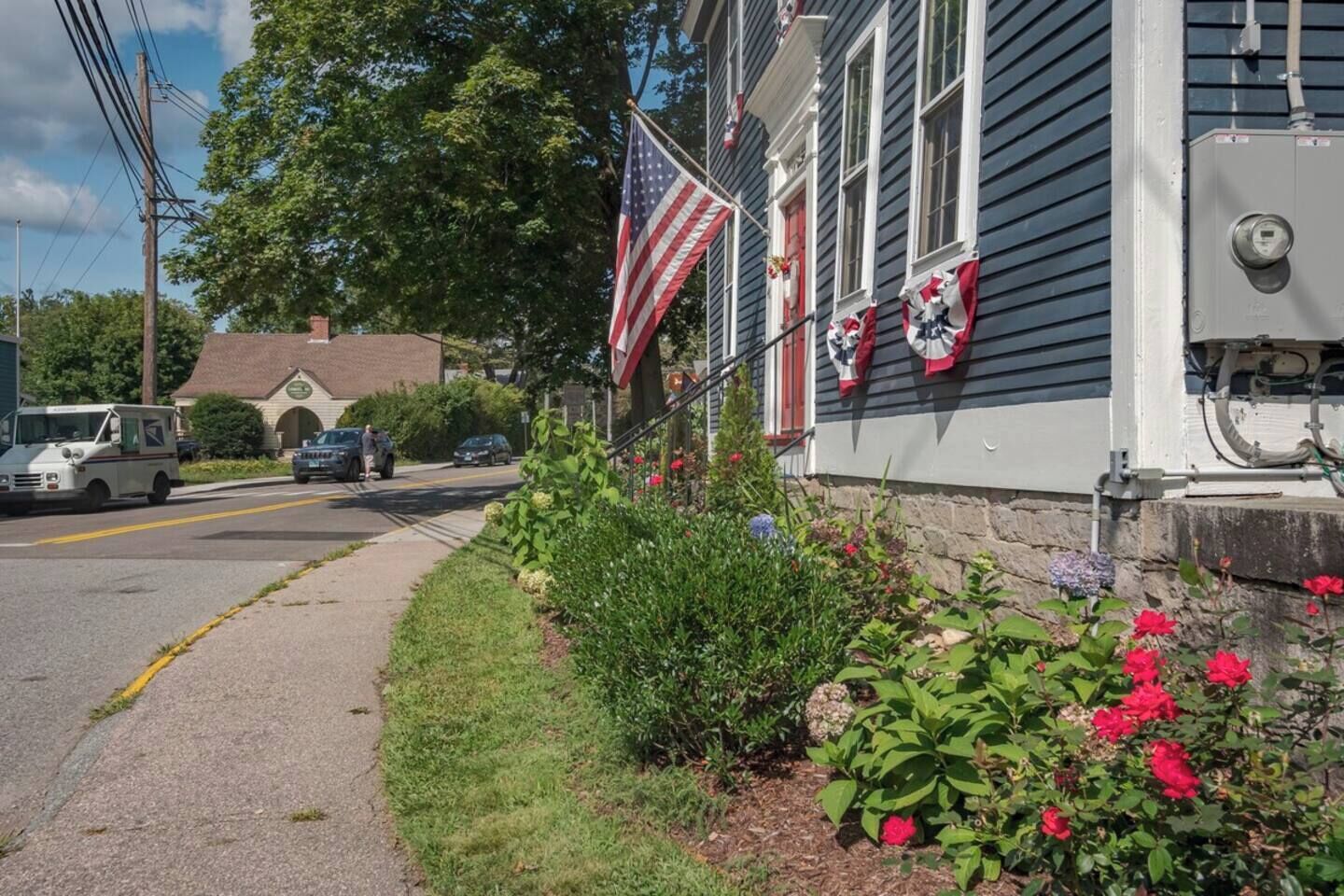 A residential house with a front yard, a mailbox, and an American flag.