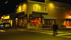 Un edificio con un letrero que dice "THE FEED STORE" y otro letrero que indica "Corner 109".