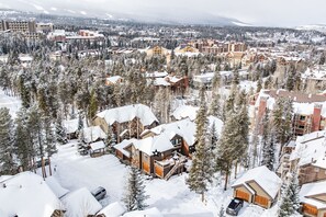 A snow-covered lodge with multiple buildings, surrounded by dense evergreen trees. - Bright 1 Bedroom, Close to Downtown & Peak 9 (Breckenridge)