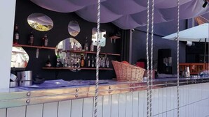Een bar met een schommelzitje, een toonbank met flessen en een spiegel.