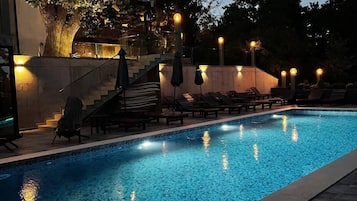 Una piscina al aire libre de temporada, sombrillas