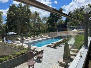A pool area with lounge chairs and a swimming pool, surrounded by trees. - The Residence Mountain Resort (Tbilisi)